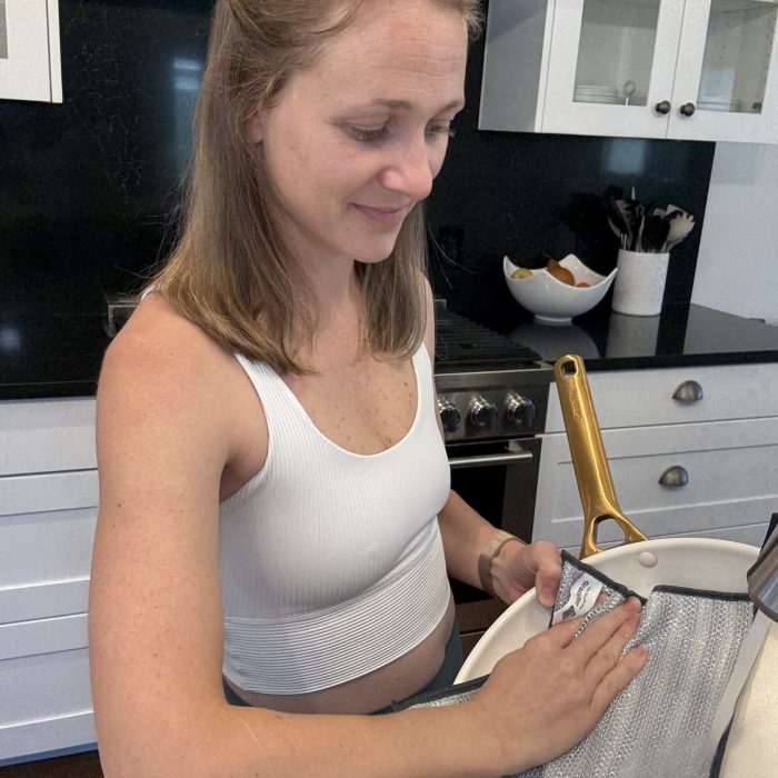 Woman cleaning a non-stick pan with Severn Dish Cloth dual-sided microfiber and mesh kitchen cleaning cloth